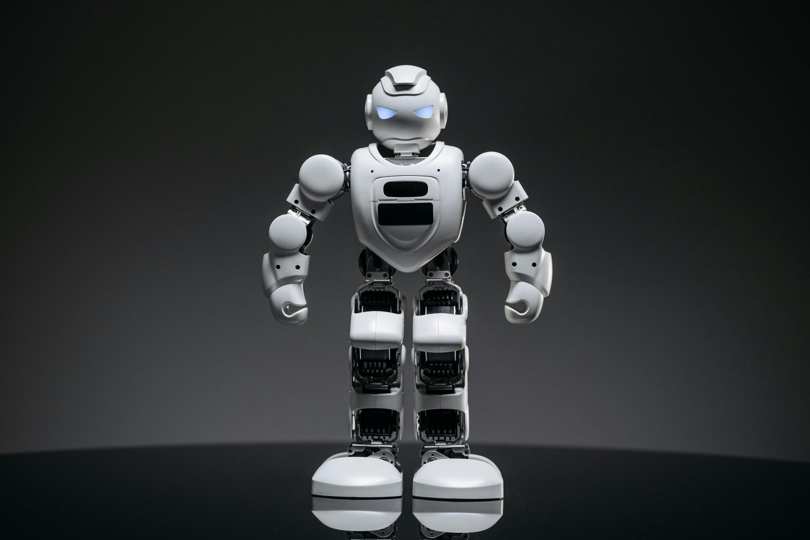 Close-up of a modern white robot with glowing eyes, symbolizing future technology and innovation.